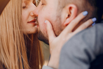 Couple in a park. Blonde in a brown coat. Man with a beard