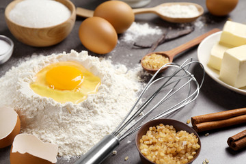 Fresh ingredients for delicious homemade cake on grey table
