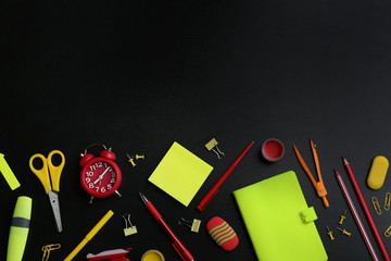 Different bright school stationery on black background, flat lay. Space for text