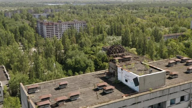 Aerial view behind Soviet hammer and sickle sign on rooftop in deserted Pripyat