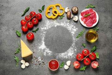 Flat lay composition with fresh pizza ingredients on grey table, space for text