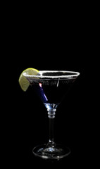 Glass of delicious cocktail on black background