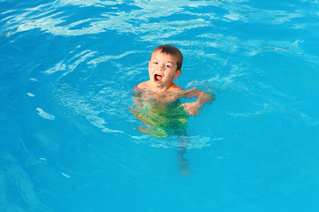 Fototapeta na wymiar Little child in outdoor swimming pool. Dangerous situation