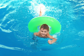 Little child with inflatable ring in outdoor swimming pool. Dangerous situation