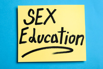 Note with phrase "SEX EDUCATION" on blue background, top view