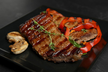 Grilled meat served with garnish on plate, closeup
