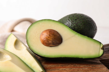 Fresh ripe avocados on wooden board, closeup view