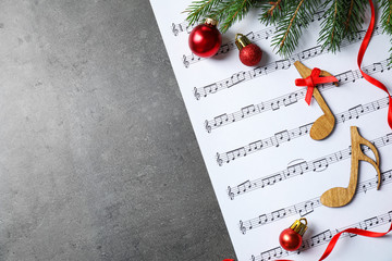 Christmas decorations, notes and music sheet on grey stone table, flat lay with space for text