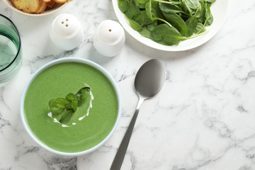 Flat lay composition with fresh green healthy spinach soup on marble table