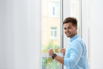 Portrait of handsome young man near window