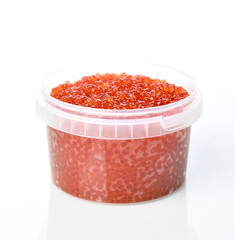 Plastic container with red salmon or keta fish caviar on white background. Sea food