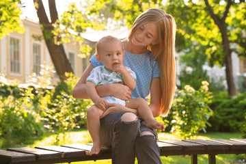 Fototapeta premium Teen nanny with cute baby outdoors on sunny day