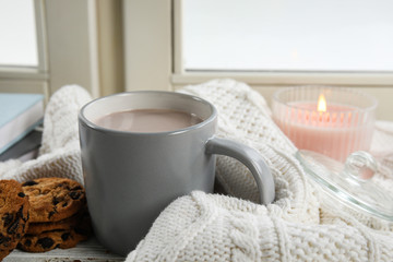 Cup of hot cocoa on window sill. Winter drink