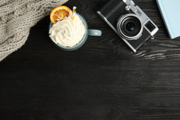 Cup of hot winter drink on black wooden table, flat lay. Space for text