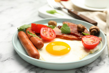 Tasty breakfast with fried egg on white marble table, closeup