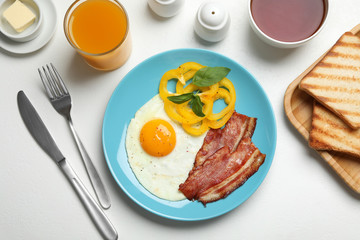 Tasty breakfast with fried egg served on light table, flat lay