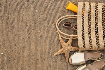 Composition with beach accessories on sand, flat lay. Space for text