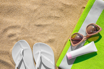 Flat lay composition with different beach accessories on sand. Space for text
