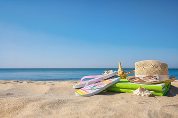 Obraz premium Set with stylish beach accessories on sand near sea
