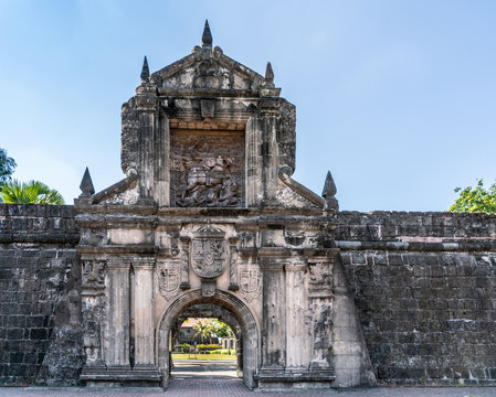 Manila, Philippines - March 5, 2019: Fort Santiago. Monumental main gate into the fortress with images of Saint James on his horse, and the coat of arms of King of Spain, all in gray stones covered in