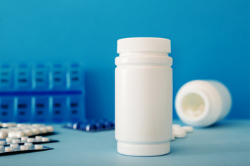 White medical pills and tablets spilling out of a bottle. Mock up bottles with copy space.