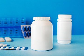 White medical pills and tablets spilling out of a bottle. Mock up bottles with copy space.