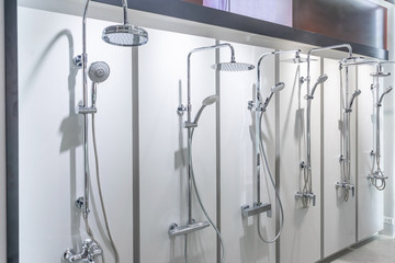 Variety of modern chrome and silver metal shower heads in the shop