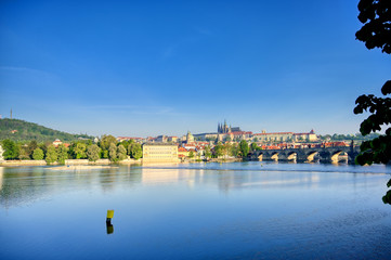 A view across the Charles Bridge and the Vltava River to Prague Castle and St. Vitas Cathedral in Prague, Czech Republic.