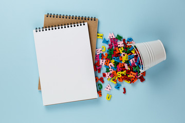 empty notebook with colored letters on a blue background