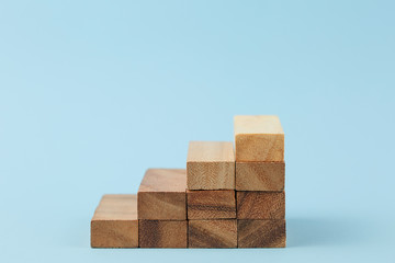 Stairs of wooden blocks on blue background.