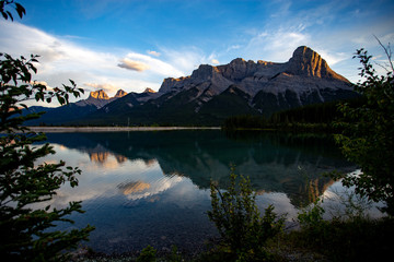 lac réfléchissant une montagne derrière dans l'ombre