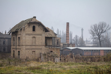 Fototapeta na wymiar Abandoned factories and warehouses with their distinctive chimneys in Eastern Europe, in Pancevo, Serbia, former Yugoslavia, during a cold winter afternoon