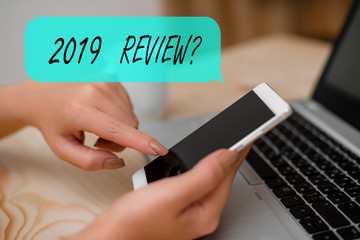 Conceptual hand writing showing 2019 Review Question. Concept meaning remembering past year events main actions or good shows woman with laptop smartphone and office supplies technology