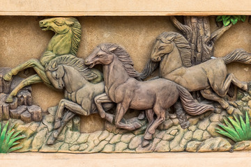 Fototapeta premium Niski relief cementu w stylu tajskim z koniem.