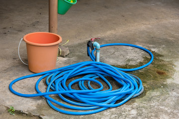 Rubber tube connected to old water tap on the floor.