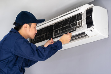technician service removing air filter of air conditioner for cleaning
