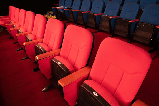 Red Blue Velvet Fabric Cloth Empty Many Seats Row Column in Movie film Theatre Concert or Siminar Conference premiere room with flare light