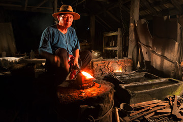 Professional Blacksmith at work is Hit the iron by a hot metal With fire