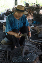 Professional Blacksmith at work is Hit the iron by a hot metal With fire