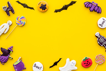 Halloween cookies in shape of spooky figures frame on yellow background top view mock up