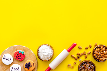 Cooking creepy cookies concept with almonds, pin, flour on yellow background top view mock-up