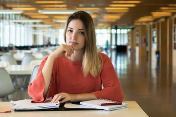 Young female student studying in the library.