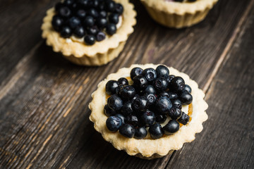 Bilberry cake decorated with fresh ripe berries on the rustic background. Selective focus. Shallow depth of field. 