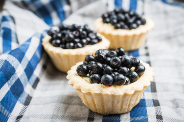 Bilberry cake decorated with fresh ripe berries on the rustic background. Selective focus. Shallow depth of field. 