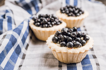 Bilberry cake decorated with fresh ripe berries on the rustic background. Selective focus. Shallow depth of field. 