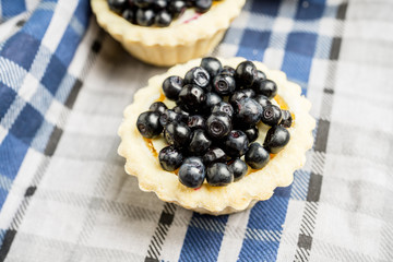 Bilberry cake decorated with fresh ripe berries on the rustic background. Selective focus. Shallow depth of field. 