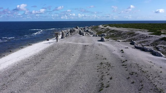 Flying along coastline towards unique limestone rocks, Low angle aerial