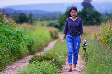 Portrait of a woman walking in a cornfield rice field.