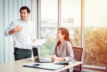 Businessman and Businesswoman discussing together in meeting room