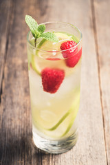 Sweet summer cocktail with raspberry and lime on the rustic background. Selective focus. Shallow depth of field.